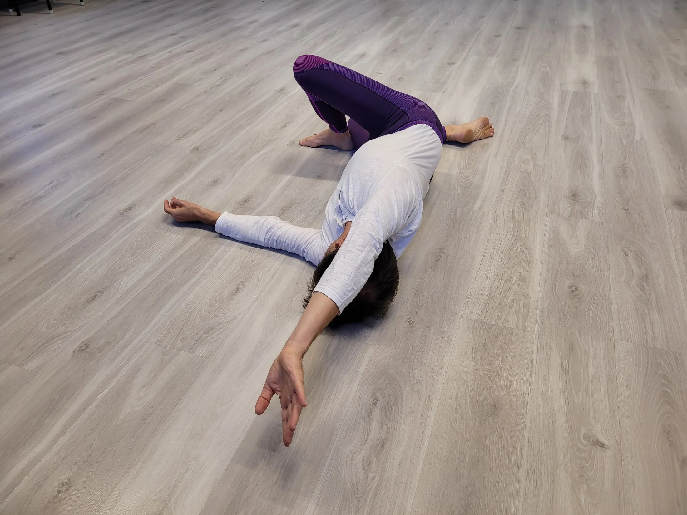 Une pratiquante allongée au sol, en position de MUNZ FLOOR.